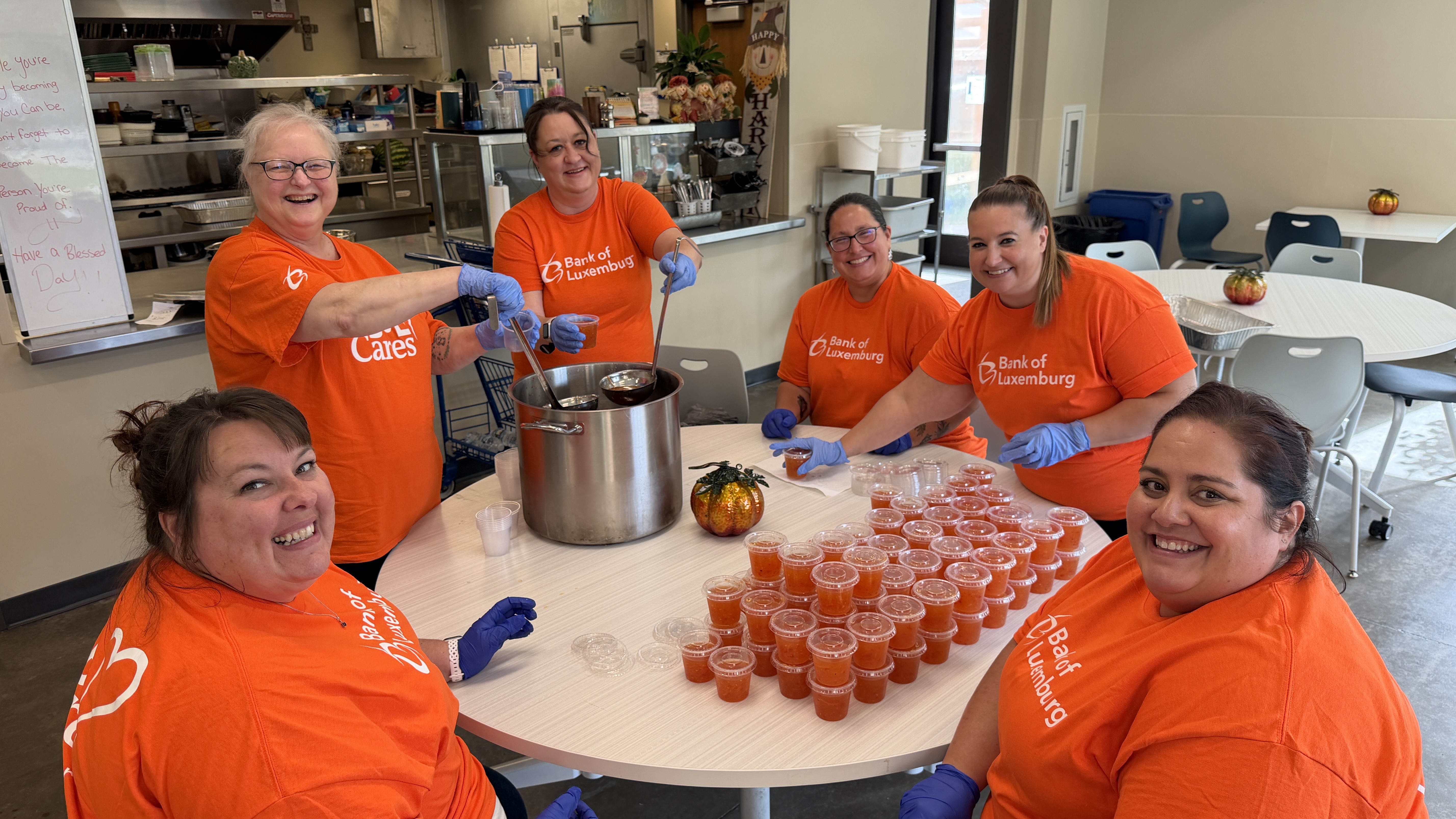 volunteers sitting at table with sauce cups