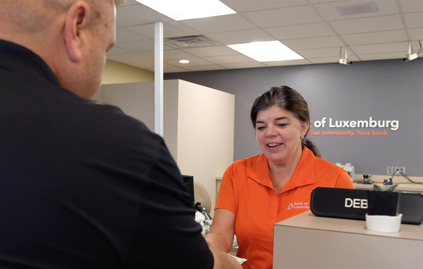 Bank of Luxemburg Teller working with a customer