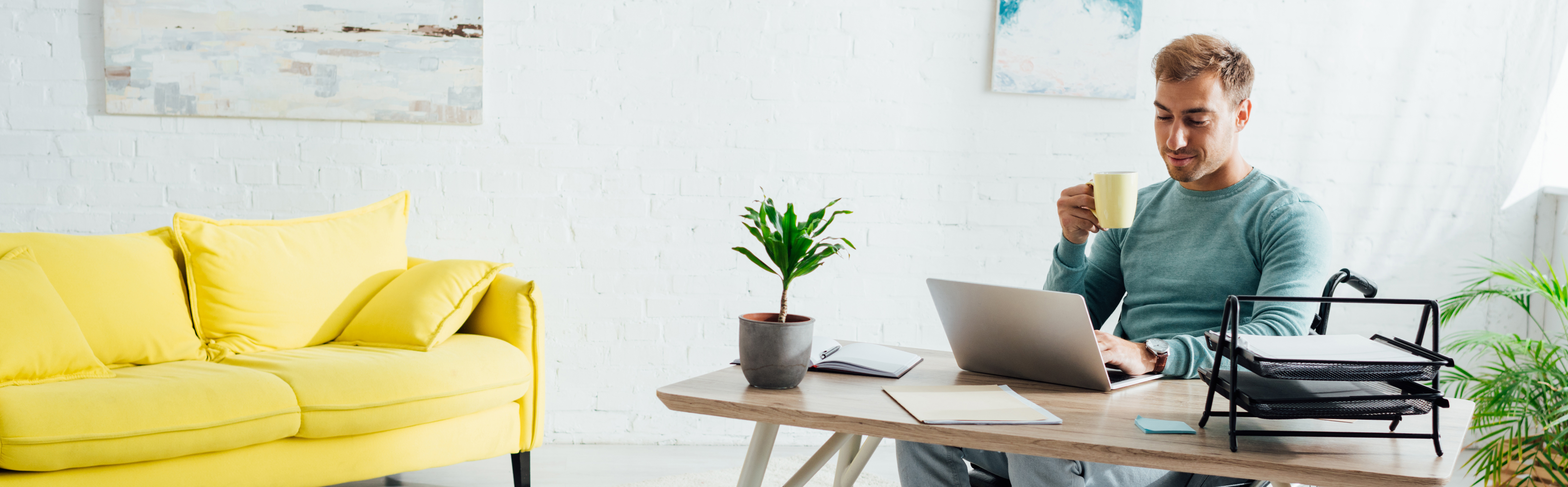 Male on computer drinking coffeee